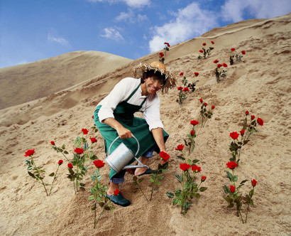 Elio Di Rupo, l'homme politique du parti socialiste pose en jardinier dans le désert avec des roses rouges.