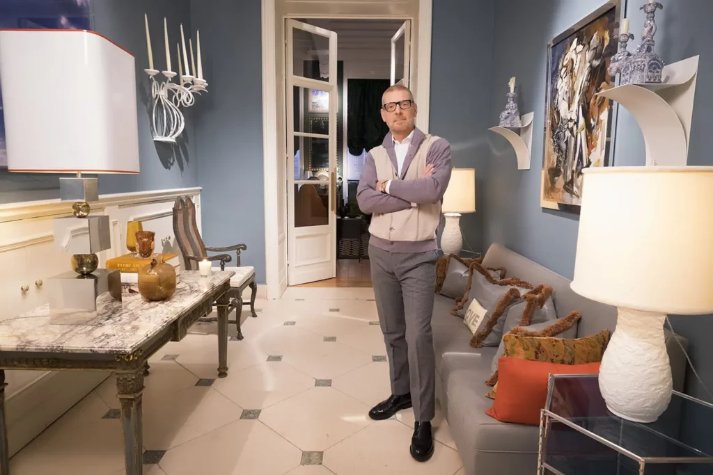 Gérald Watelet en tenue casual Crossword dans le hall d'entrée de son appartement.