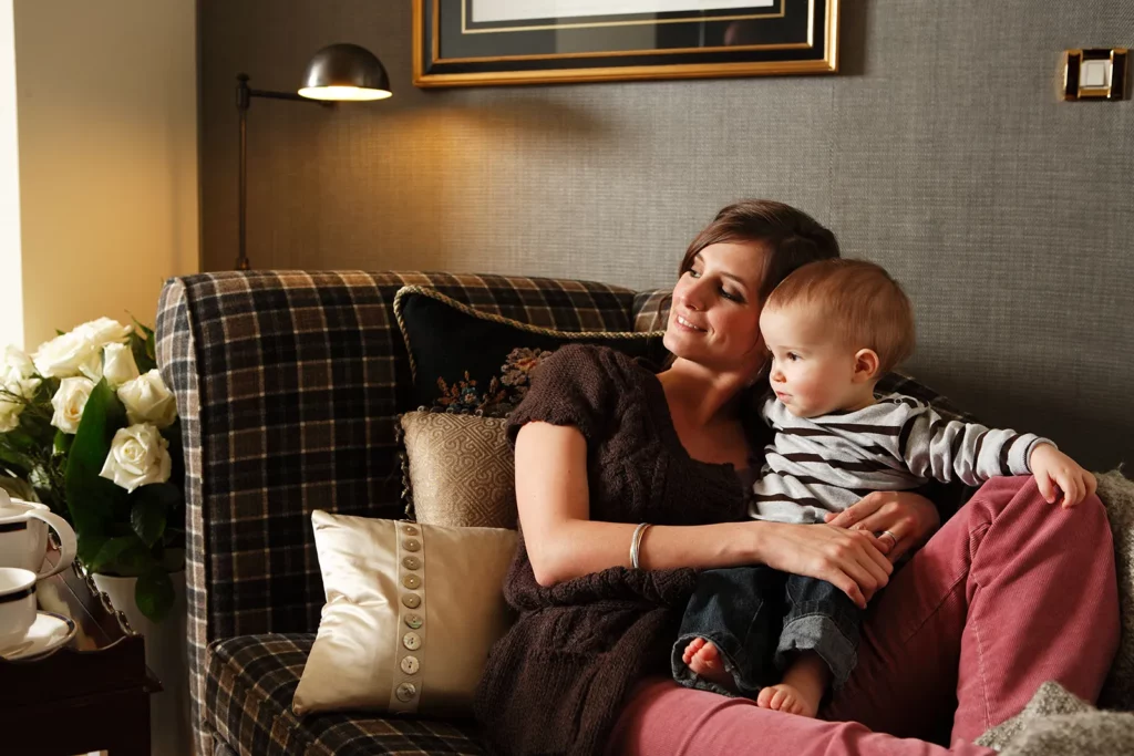 Elodie De Sélys assise sur une méridienne avec son fils Côme dans la suite Royale.