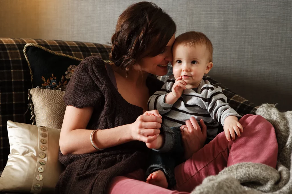 Portrait serré d'Elodie De Sélys pressant son front contre la tête de son fils Côme.