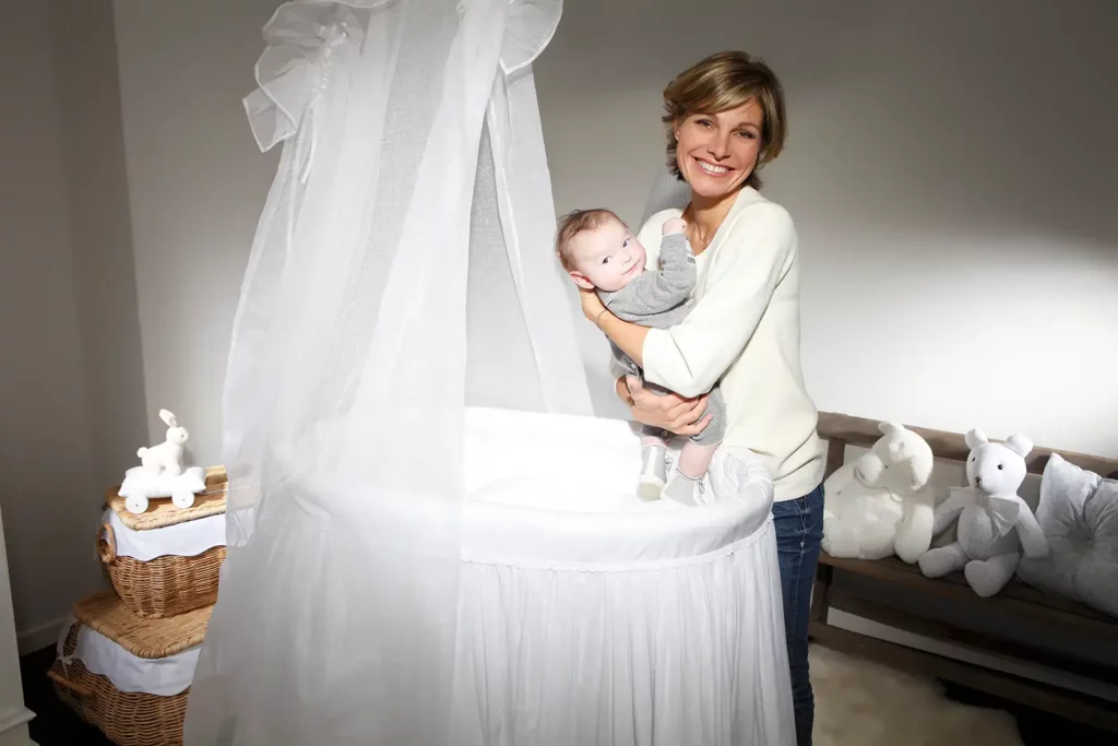 Armelle Gysen portant son bébé Douglas dans la chambre décorée par Théophile & Patachou.