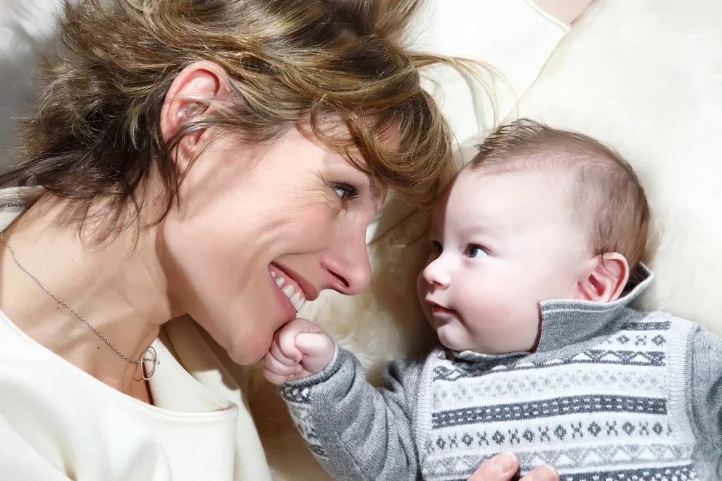 Close-up d'Armelle Gysen et son fils Douglas se regardant dans les yeux sur une peau de mouton.