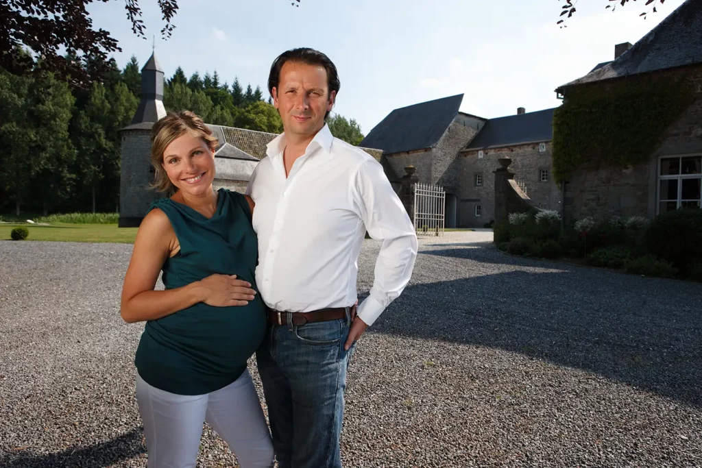 Armelle Gysen enceinte en top vert et Frédéric d'Aspremont devant la grille du Château de Ry.