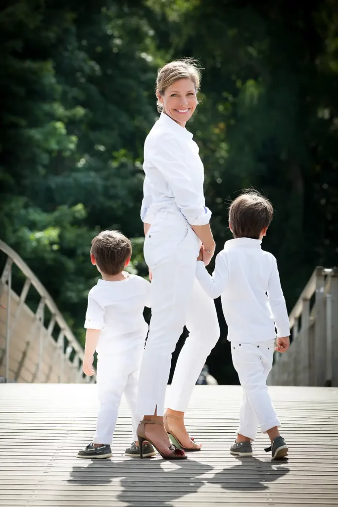 Armelle Gysen en blanc avec ses deux fils sur la passerelle de la promenade verte.