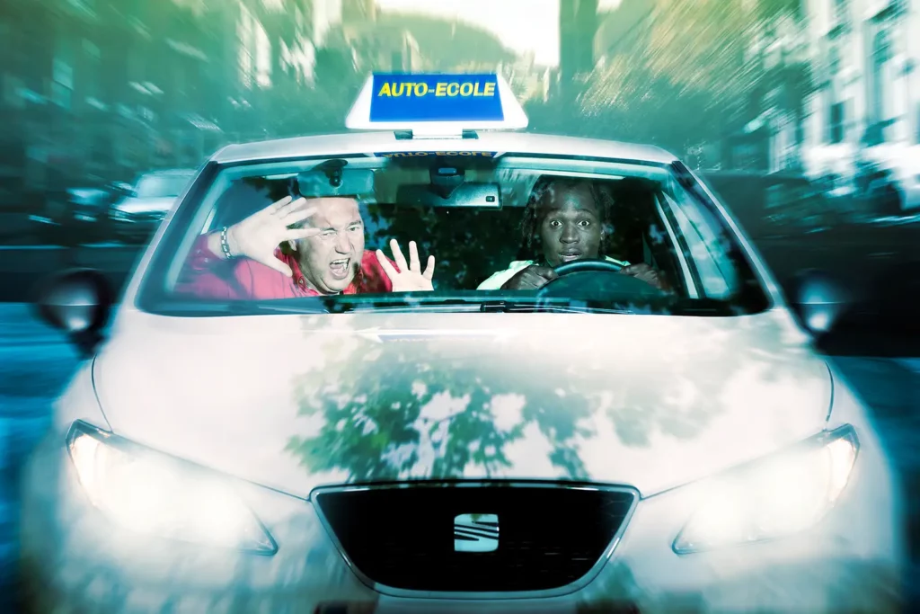 Romelu Lukaku au volant d'une Seat auto-école, mimant la surprise, avec Marc Duez en passager faisant mine d'avoir peur.