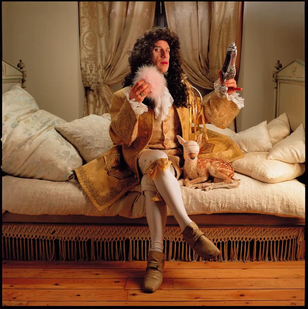 Elvis Pompilio déguisé en Roi Soleil avec perruque et miroir vintage, portrait artistique par le photographe Michel Gronemberger à Bruxelles.