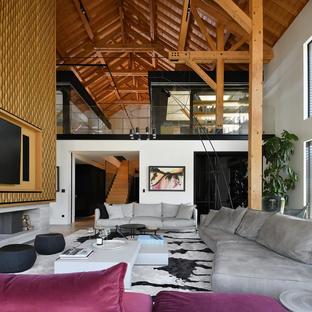 Intérieur d'un manoir contemporain de 1597 m² avec baies vitrées, murs en bois blanc et parquet en Haute-Savoie pour shooting photo.