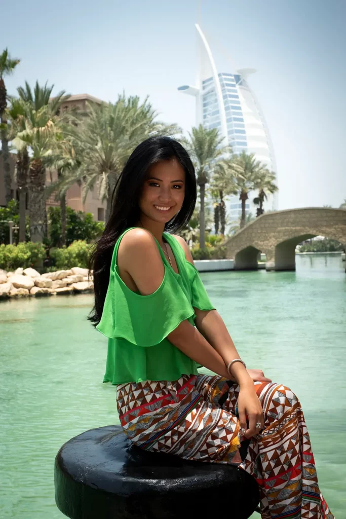 Angéline Flor Pua (Miss Belgique) assise sur une bite d'amarrage devant le Burj Al Arab à Dubaï.