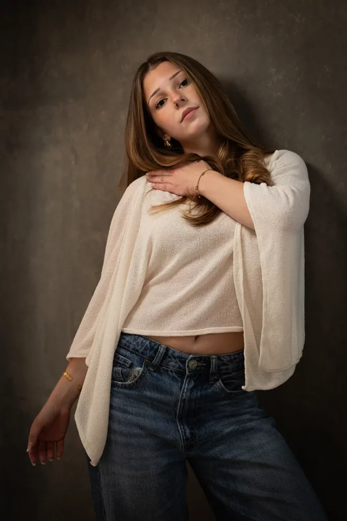 Meilleur photographe pour book modèle à Bruxelles, séance photo studio d'une jeune femme posant la main sur l'épaule.