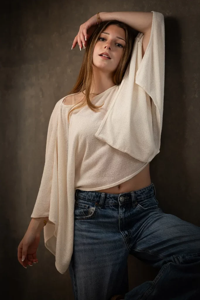 Photographe professionnel book modèle Bruxelles, portrait de style mode d'une jeune femme au menton relevé et regard assuré en studio.