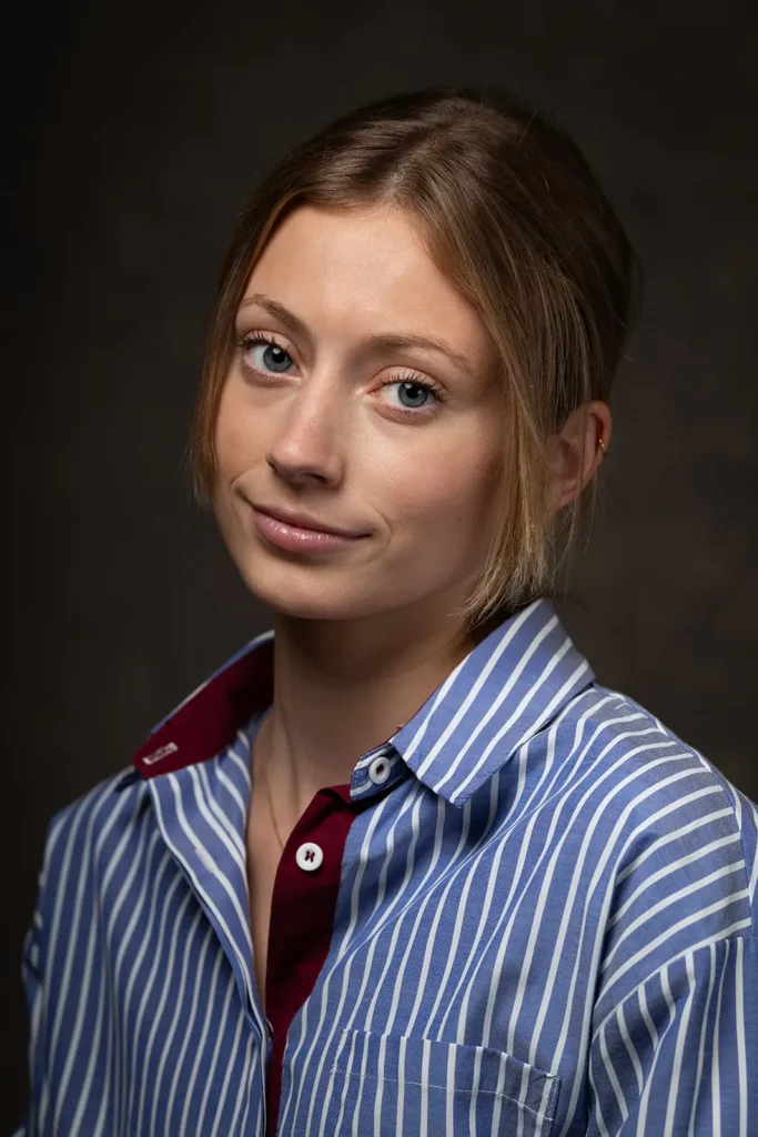 Cadrage serré d'un portrait professionnel CV au style décontracté avec un chemisier rayé bleu et blanc.