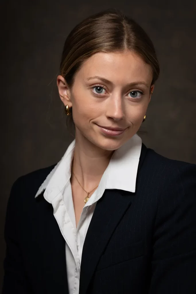 Cadrage serré d'un portrait professionnel CV pour une étudiante en Master portant une veste de tailleur noire en studio.